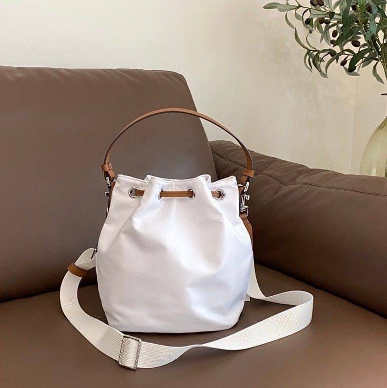 Tory Burch Virginia Nylon Bucket Bag / Tory Burch logo-plaque bucket bag กระเป๋าสะพายทรงบัคเก็ต เปิด-ปิดหนังรูดปากกระเป๋า มีหูหิ้วในตัว คล้องแขนเก๋ๆ ภายในเป็นช่องโล่ง มีช่องย่อย ใส่ของสำคัญจุกจิกได้ มีสายครอส จะสะพายไปไหนก็ได้ทุกโอกาส สวยเลิศทุกสี พร้อมส่