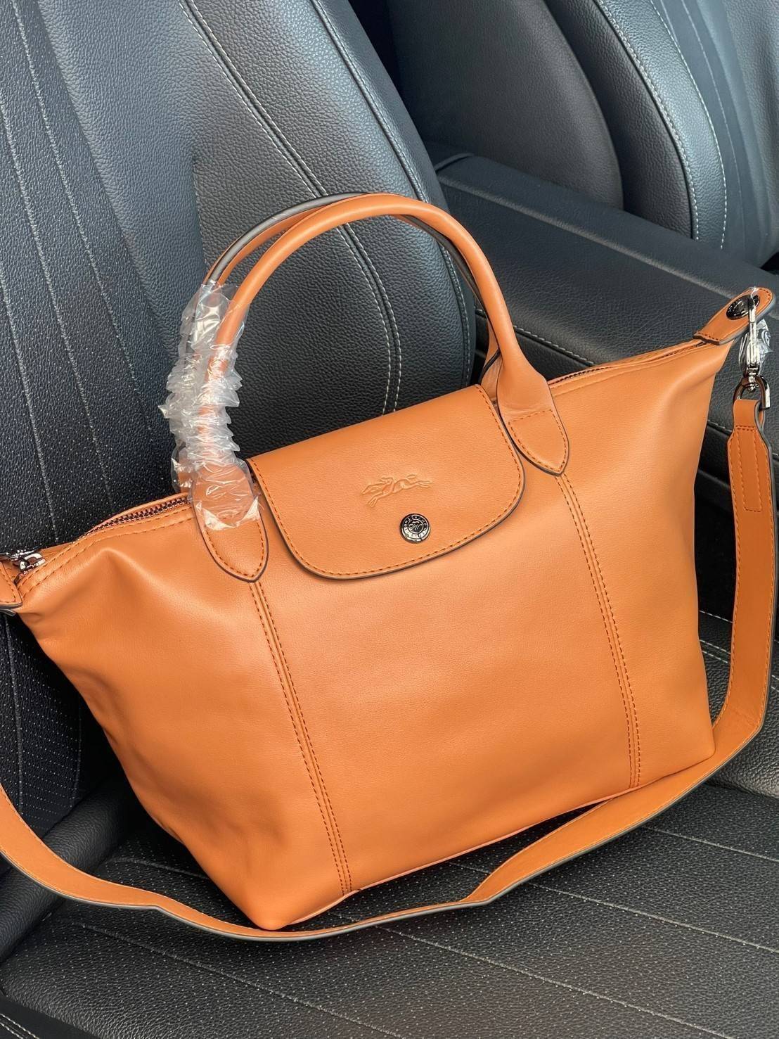 Longchamp Le Pliage Cuir Top handle bag S เรียกว่าเป็นกระเป๋าอีกหนึ่งรุ่นที่ไม่ว่ายังไงก็ฮอตฮิตและติดเทรนด์ตลอดไม่เคยเปลี่ยนกับ ทรง Le Pliage Cuir หนึ่งในตระกูลกระเป๋าสุดไอคอนิกจากแบรนด์