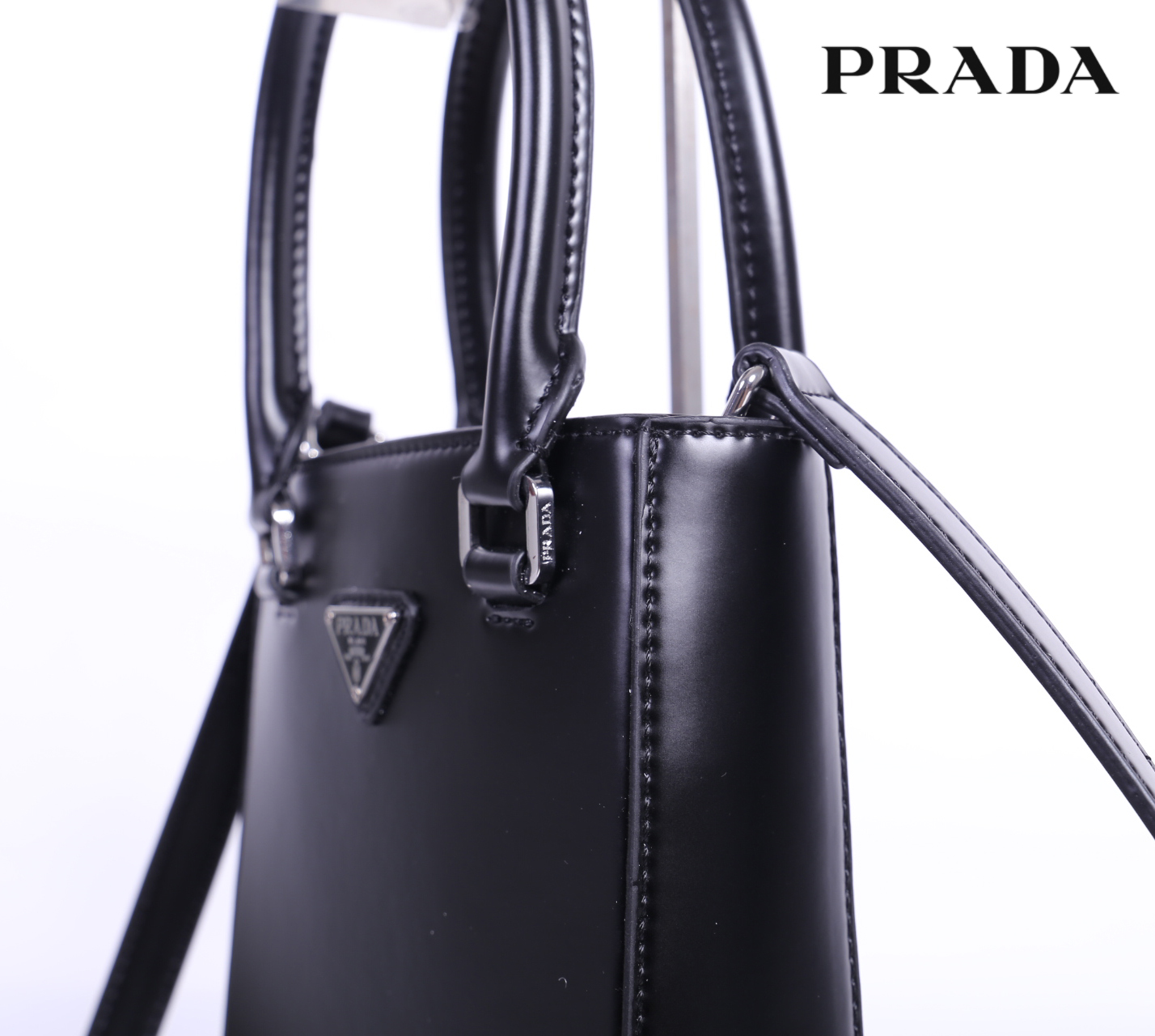 PRADA Small brushed leather tote กระเป๋าTote ขนาดเล็กที่มีดีไซน์ทรงเหลี่ยมโฉบเฉี่ยว วัสดุจากหนังเงาซึ่งเป็นวัสดุที่โดดเด่นของแบรนด์มาตั้งแต่ยุค 90'