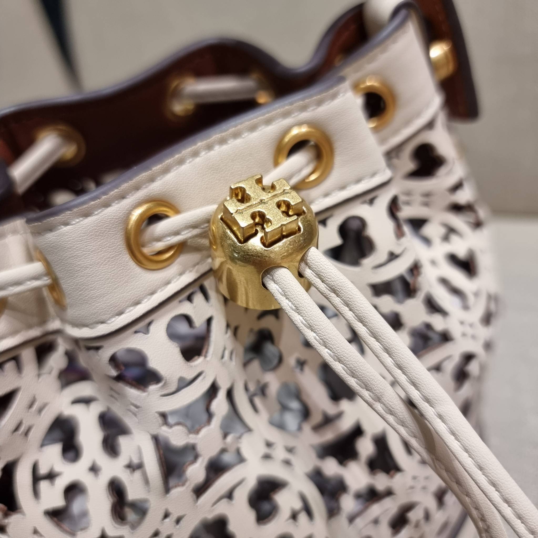 TORY BURCH T MONOGRAM LASER-CUT MINI BUCKET BAG ใจบางที่สุดกับคอลเลคชั่นนี้ กับกระเป๋าสะพายทรงบัคเก็ต ไซส์มินิ รุ่นชูโรงสุดฮิต ที่เพิ่มดีเทลความแพงด้วยการฉลุลวดลายโมโนแกรมรอบใบ ถักทอเป็นเส้นลายสานที่สวยงามมาก งานฝีมือจริงๆ วัสดุหนัง cowhide รูดเปิด-ปิดด้ว