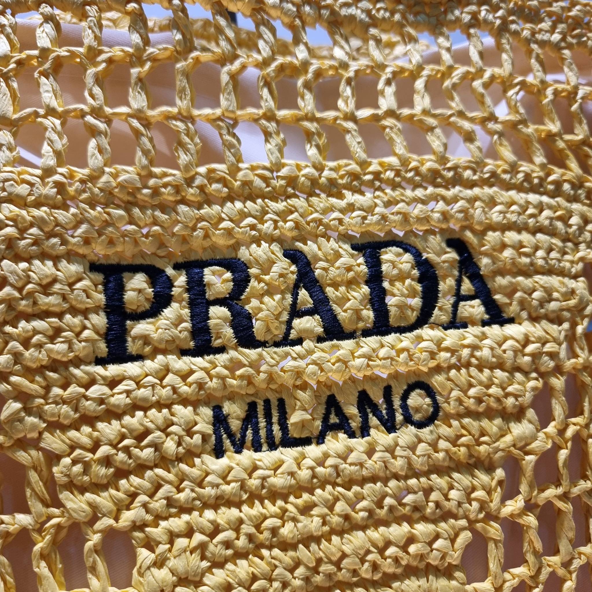 PRADA RAFFIA TOTE BAG สวยไม่ซ้ำใคร สไตล์บีช เหมาะมากกับการสะพายไปเที่ยวทะเล หรือจะใช้ในวันสบายๆก็ตอบโจทย์ กับกระเป๋าสะพายสานใบใหญ่ ตัวกระเป๋าเป็นวัสดุสังเคราห์จากธรรมชาติ