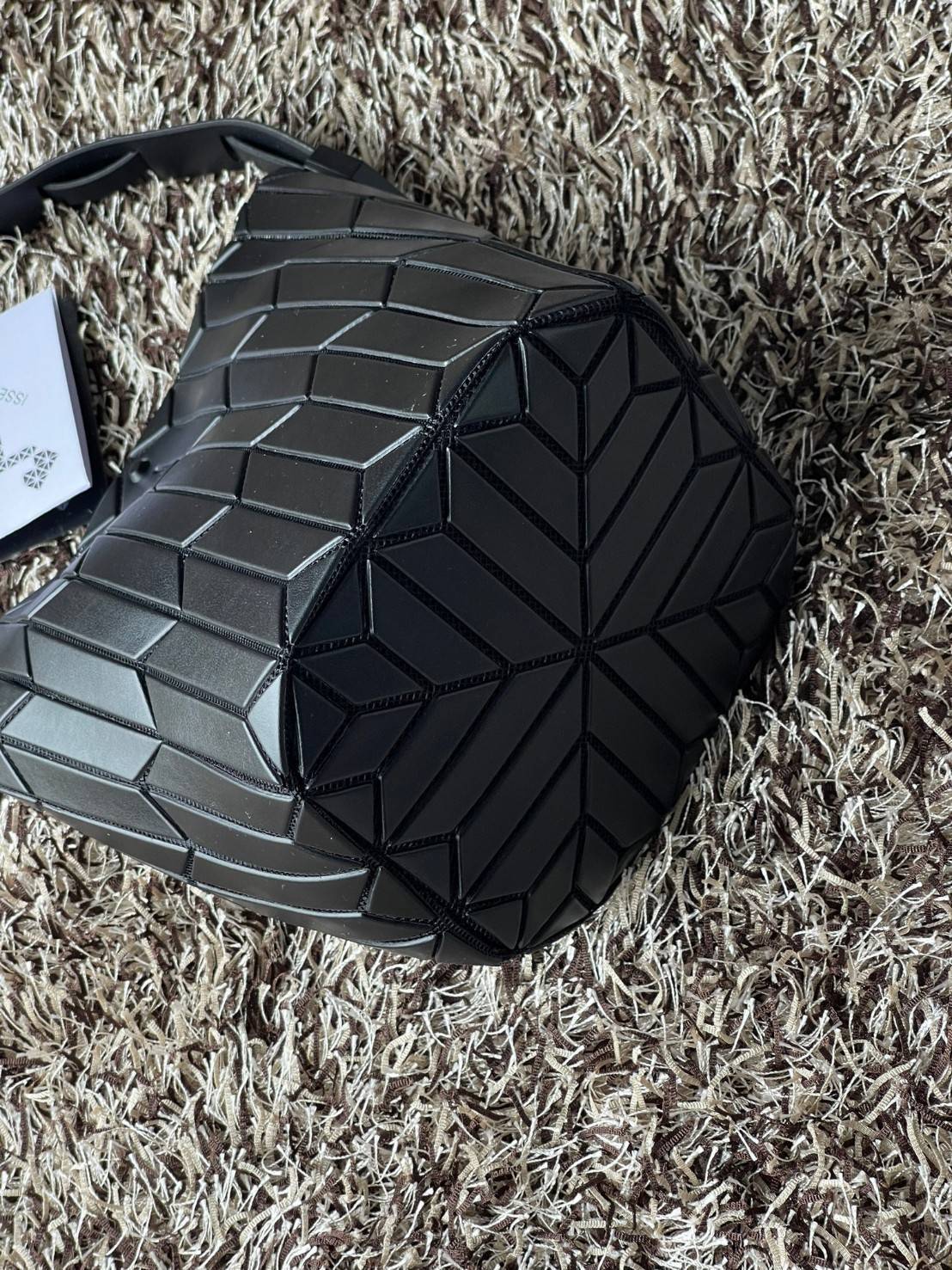 Small : BAO BAO ISSEY MIYAKE SMALL BUCKET เป็นกระเป๋าบัคเก็ตขนาดเล็กสามารถใช้ใส่กระเป๋าสตางค์และโทรศัพท์มือถือได้ ซีรีย์ใหม่นี้มีจุดเด่นที่แผ่นรูปทรงสี่เหลี่ยมด้านขนานในแนวตั้ง เกิดเป็นรูปทรงสามมิติซึ่งแตกต่างไปจากรูปทรงที่เกิดขึ้นจากแผ่นสามเหลี่ยม หูหิ้ว