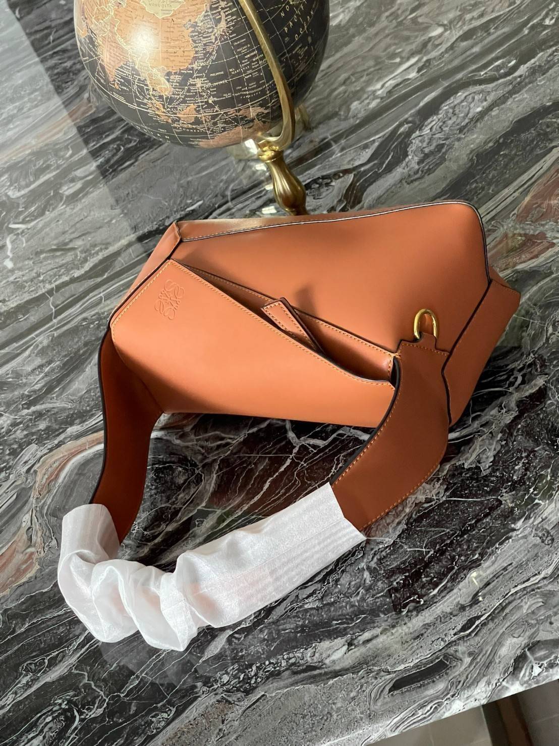 Loewe Puzzle Hobo bag กระเป๋ารุ่น Puzzle มีความพิเศษในหลายด้าน ไม่ว่าจะเป็นรูปทรงที่แปลกใหม่ มินิมอลด้วยโลโก้อนาแกรมแบบประทับ ดูหรู เป็นกระเป๋า Unisex ที่ไม่ว่าคุณจะเป็นผู้หญิงหรือผู้ชายก็ใช้งานได้ ลายกระเป๋าได้มาจากการนำหนังมาเย็บต่อกันทั้งหมด ถึงแม้ว่าข