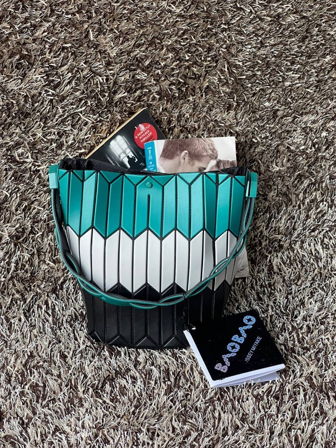 Small : BAO BAO ISSEY MIYAKE SMALL BUCKET เป็นกระเป๋าบัคเก็ตขนาดเล็กสามารถใช้ใส่กระเป๋าสตางค์และโทรศัพท์มือถือได้ ซีรีย์ใหม่นี้มีจุดเด่นที่แผ่นรูปทรงสี่เหลี่ยมด้านขนานในแนวตั้ง เกิดเป็นรูปทรงสามมิติซึ่งแตกต่างไปจากรูปทรงที่เกิดขึ้นจากแผ่นสามเหลี่ยม หูหิ้ว