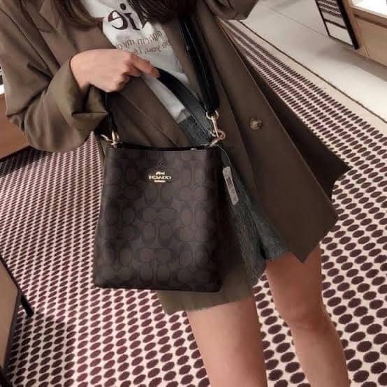 COACH SMALL TOWN BUCKET BAG IN SIGNATURE สำหรับสาวแฟชั่นที่ชอบรายละเอียดชิคๆ ดีไซน์สุดเก๋ แนะนำเลยสำหรับกระเป๋าทรงบักเก็ตใบนี้ เชื่อว่าสาว ๆ หลายคนชื่นชอบ เป็นไอเทมที่สามารถแมทช์ได้กับเสื้อหลากหลายสไตล์ บรรจุของได้เยอะโดยที่กระเป๋าไม่เสียทรง แบ่งช่องใช้งา