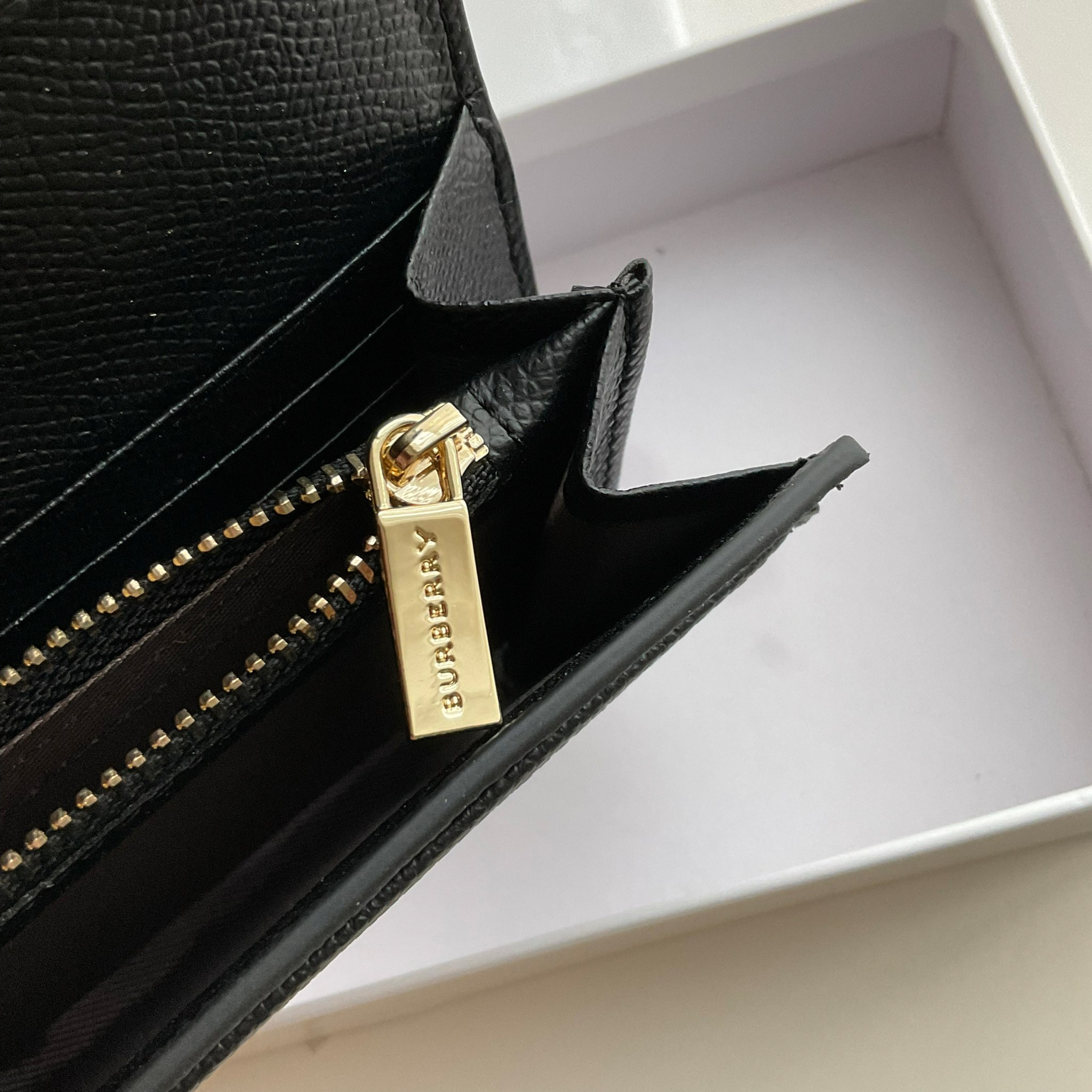 กระเป๋าสตางค์รับทรัพย์ ทรงหรู จากงาพรีเมี่ยมกิ๊ฟ Limited Edition จาก BURBERRY กระเป๋าสตางค์ใบยาวแบบพับกระดุม ทูโทนด้วยหนังแท้คาดผ้าลาย vintage ด้านในมีช่องใส่ธนบัตรยาวทั้งสองฝั่ง ช่องใส่บัตรได้อย่างน้อย 12 ช่อง และช่องเปิดด้วยซิปปั้มแบรนด์อะไหล่ทองสุดหรู 