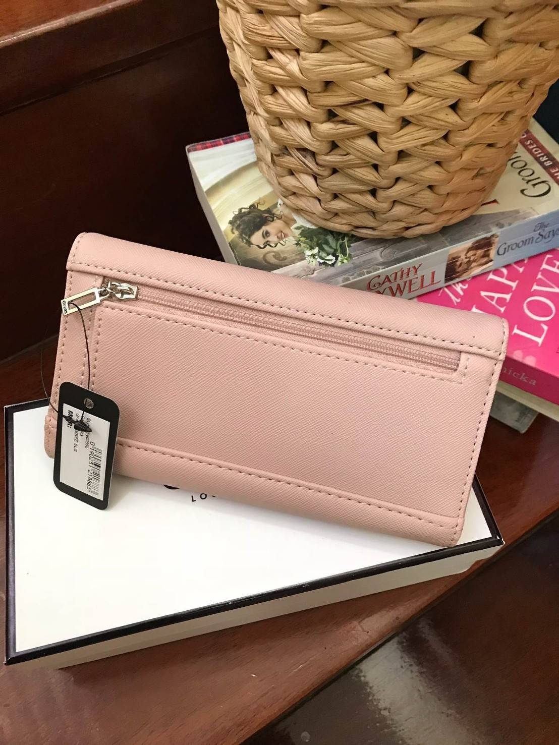 GUESS FACTORY WOMEN'S LONG WALLET กระเป๋าสตางค์ทรงยาวแบบสามพับ วัสดุหนังลายsaffiano เปิดปิดด้วยกระดุมสะดวกใช้ ภายในมีทั้งช่องซิปใส่เหรียญ ช่องใส่ธนบัตรและช่องใส่บัตรหลายช่องและช่องใส่รูปแยกเป็นสัดส่วน ด้านหน้ามีโลโก้แบรนด์ทรงสามเหลี่ยม ด้านหลังมี1ช่อ