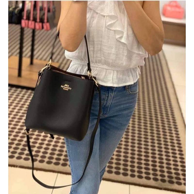 COACH 1011 SMALL TOWN BUCKET BAG รุ่นยอดนิยมใบเล็ก กระเป๋าทรงบัคเก็ต สีคลาสสิคเรียบหรู ตัดกับโลโก้สีทองดูโดดเด่น วัสดุหนัง pepble สวยคมทุกมุมจริงๆ!! เปิด-ปิดด้วยกระดุมแม่เหล็กทั้ง 2 ฝั่ง ภายในเป็นช่องโล่ง มาพร้อมสายสะพายปรับได้ตามตัว ขนาดใบนี้กำลังสวย สะพ