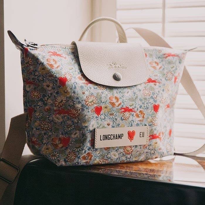 Longchamp X Eu Backpack กระเป๋าเป้สะพายหลังลายดอกๆไม้ วัสดุผ้าฝ้าย อะไหล่สีดำ กระเป๋าเป้แบบลำลองสำหรับสตรีซึ่งนำรูปทรงอันเป็นเอกลักษณ์ของ Le Pliage มาปรับใช้กับทุกสถานการณ์ อุปกรณ์เสริมที่ใช้งานได้จริงนี้มีสายรัดปรับระดับได้และที่จับช่วยให้ สะพายข้างหรือส