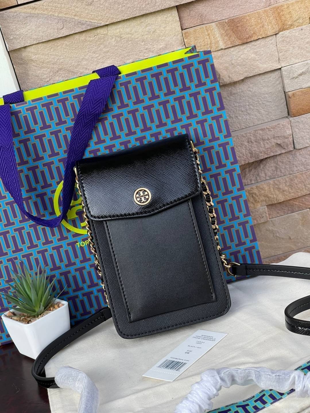 OUTLET 】Tory burch robinson mixed materials phone crossbody ไอเท็มหรูจากแบรนด์ดังอย่างTory burch อีกแบรนด์สุดคลาสสิกที่มีทั้งความเท่และความเรียบหรูลงตัว กับรูปทรงแบบมินิมอลสีเหลี่ยมมุมโค้งเรียบ ๆ ดีไซน์ฝาพับปิดกระเป๋าได้มิดชิด ยังมีลักษณะที่แนบกับตัวผู้ใช