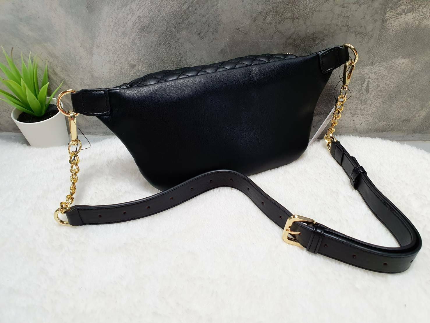 กระเป๋า Guess รุ่นนี้คาดเอว/คาดอก/สะพายข้างได้ครบทุกฟังก์ชั่น ด้านหน้าหนังเป็นลายตาราง ติดโลโก้แบรนด์รูปสามเหลี่ยมด้านหน้า เปิดปิดด้วยซิปยาว ด้านในเป็นช่องกว้างมีช่องซิปด้านใน ตัวกระเป๋าด้านหลังเป็นหนังเรียบ รุ่นนี้มีสายสะพายมา 2 เส้น เส้นแรกเป็นสายหนังปร