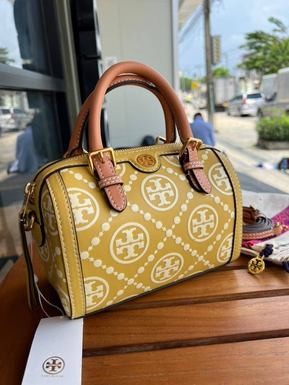Tory Burch T-Monogram Mini Embossed Wine Bucket Bag / Tory Burch Mini Bucket กระเป๋าถือหรือสะพายไหล่ ทรงหมอนขนาดเล็ก ประดับด้วยลวดลายอันเป็นสัญลักษณ์ของแบรนด์ ถูกประดิษขึ้นด้วยความพิถีพิถันวัสดุหนังอย่างดี ด้านในบุด้วยหนังไมโครซูแอคเนื้อนุ่มทำความสะอาดง่า