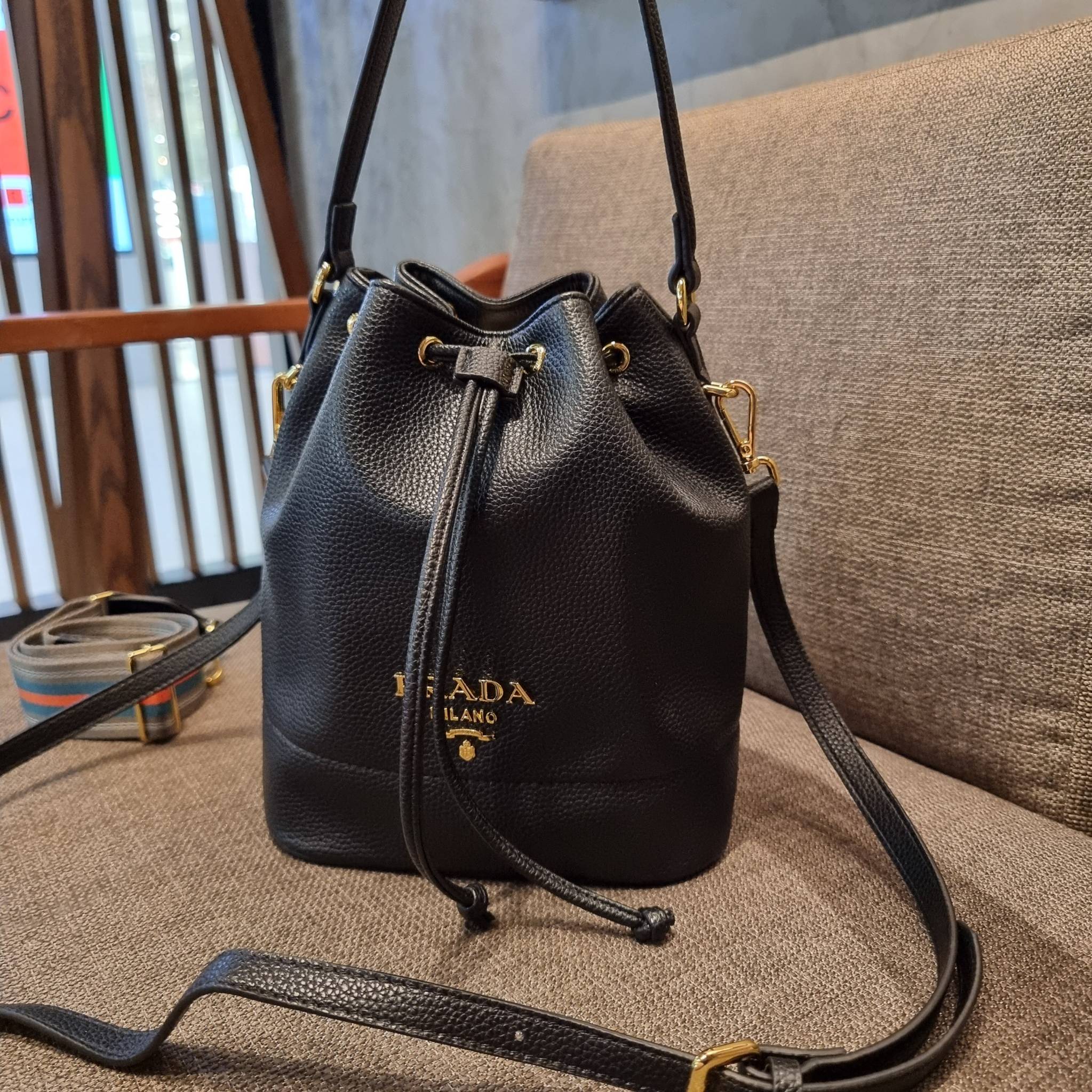 Prada leather bucket bag กระเป๋าสะพายทรงขนมจีบ ดีไซน์เรียบ แต่หรู น่าใช้มากๆ หนังสวยมาก วัสดุหนัง pepble สัมผัสนิ่มมือ ตกแต่งโลโก้สีทองตัดหนังดำ คือเลิศ!! ปากกระเป๋ารูดเปิดปิดได้ สะดวกใช้งาน ภายในโล่งกว้าง จุของได้เยอะ ไม่ธรรมดาเลย พิเศษ!! นอกจากสายคล้องใ