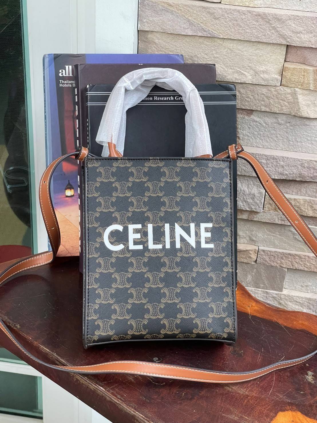CELINE MINI VERTICAL CABAS IN TRIOMPHE CANVAS มีโลโก้ CELINE สกรีนอยู่ตรงกลาง ถือเป็นกระเป๋า Tote ที่ทำจากแคนวาสที่น่าสนใจมาก ๆ อีกรุ่นหนึ่ง และเป็นรุ่นที่ได้รับคำชื่นชมจากแฟชั่นกูรูทั้งหลายอีกด้วย หากใครที่อยากเป็นเจ้าของกระเป๋า Tote จาก CELINE สักใบ รุ่