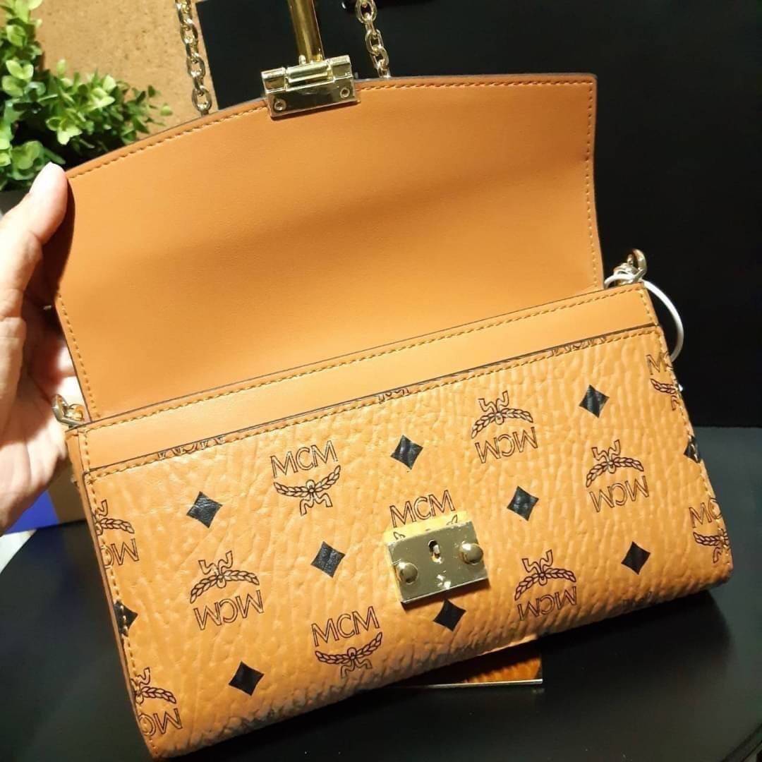 M.C.M MEDIUM MILLIE FLAP CROSSBODY IN VISETOS ฮอตที่สุดอีกหนึ่ง กระเป๋าสะพายกึ่งคลัทช์ มาพร้อมสายสะพายโซ่สีทองหรูหรา รูปทรงดีไซน์ร่วมสมัย ใช้งานง่ายด้วยตัวล็อค วัสดุภายนอกเป็นหนังแคนวาสคุณภาพดี ภายในเป็นหนังแท้สลับผ้า มีช่องซิปแยกอย่างดี ขนาดใบนี้กำลังดีม