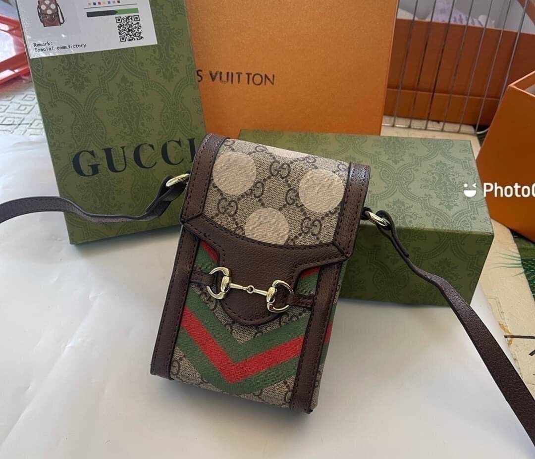 VIP 】GG CANVAS AND LEATHER CROSS-BODY PHONE BAG พร้อมส่งที่ไทย Brown canvas Brown Ophidia GG Supreme mini bag from GUCCI featuring an adjustable shoulder strap, a foldover top, a GG Supreme pattern, a Web stripe to the front and a gold-tone Double G plaqu