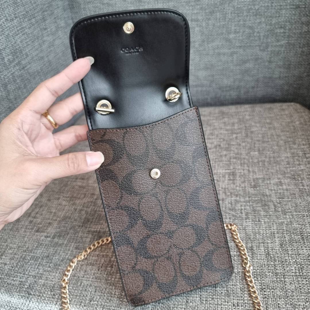 COACH NORTH/SOUTH PHONE CROSSBODY IN SIGNATURE CANVAS F55636 F39955 สุดคลาสสิคกับกระเป๋าสะพายเอนกประสงค์ Case phone ใส่โทรศัพท์มือถือได้ทุกรุ่น ดีไซน์ลายเอกลักษณ์ วัสดุหนังแคนวาสเคลือบลาย ฝาและภายในเป็นหนังสังเคราะห์เรียบ เปิด-ปิดด้วยกระดุม สายสะพายยาวประ