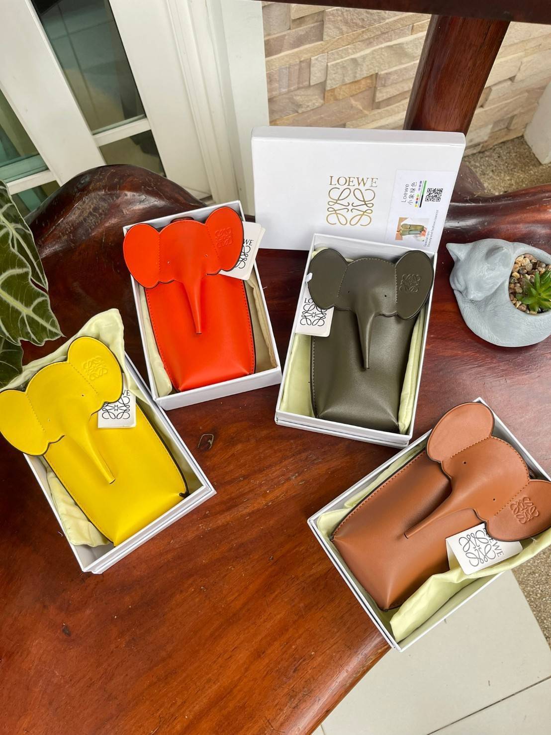 Loewe Leather Elephant Phone Holder แบรนด์หรูจากประเทศสเปนอย่าง โลเอเว่ (LOEWE) หลายๆคนคงนึกถึงกระเป๋ารูปทรงช้างขนาดเล็ก ที่เป็นเหมือนหนึ่งในซิกเนเจอร์ของแบรนด์ มีทั้งแบบสะพายข้าง แบบถือ รวมไปถึงในแบบเครื่องหนังชิ้นเล็กอย่างกระเป๋าใส่มือถือรุ่นนี้ ผลิตจาก