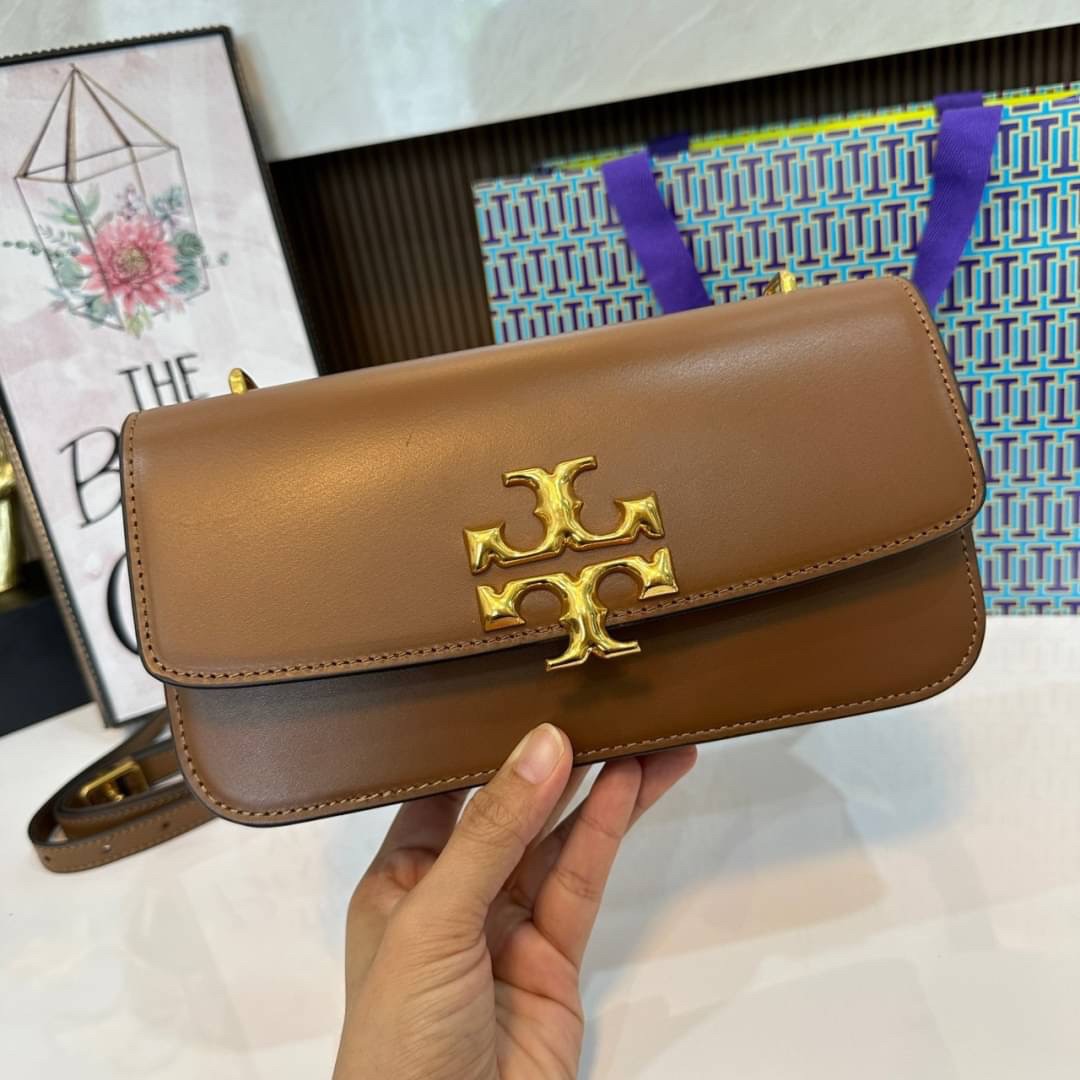 TORY BURCH ELEANOR SMALL LONG CONVERTIBLE SHOULDER กระเป๋าสะพายทรงยาว E/W Eleanor Convertible สูดหรู ดูแพง หนังแท้ เรียบสวยหรู โดดเด่นด้วยป้ายโลโก้สีทอง ลาย Double T อันเป็นเอกลักษณ์ ภายในช่องโล่งกว้างสามารถใส่โทรศัพท์ได้ทุกรุ่น สามารถใส่กระเป๋าสตางค์ใบยา