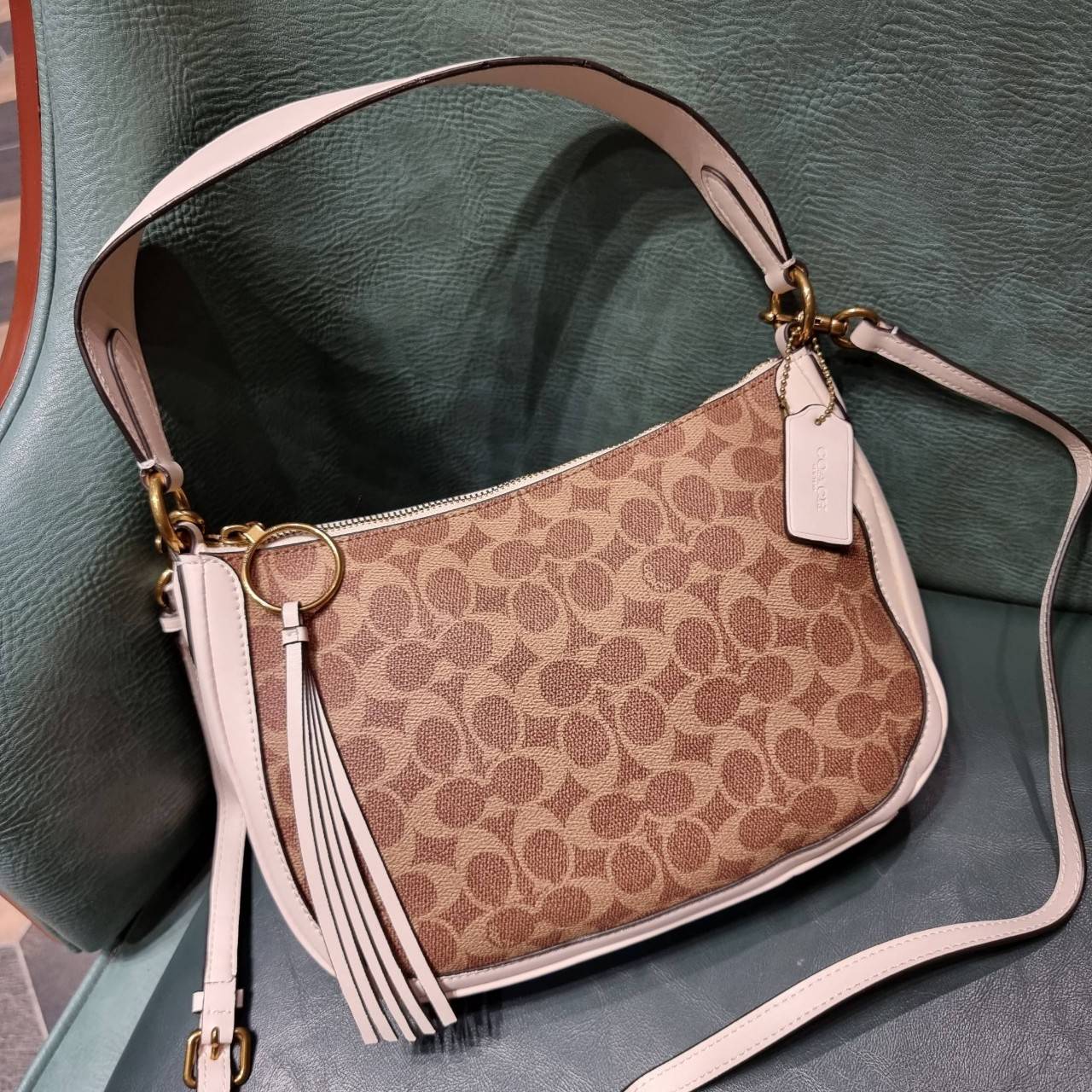 COACH 52577 SUTTON CROSSBODY IN SIGNATURE CANVAS กระเป๋าสะพายไหล่ สวยคลาสสิค สไตล์วินเทจ ใบใหญ่จุใจ วัสดุหนังแคนวาสเคลือบลาย สายคล้องไหล่ในตัว ภายในโล่งกว้าง จุของได้เยอะแน่นๆ มาพร้อมสายสะพาย crossbody ที่จะถอดออก หรือจะสะพายก็เก๋ สวยโดดเด่นแน่นอน พร้อมเส