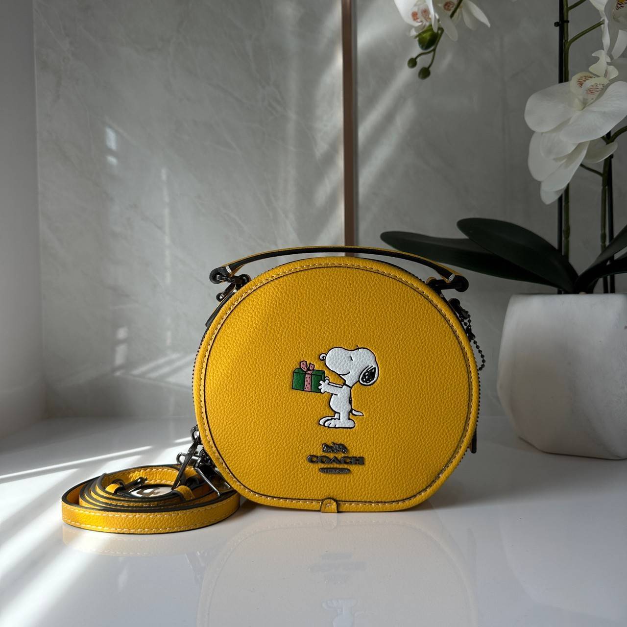 COACH X PEANUTS CANTEEN CROSSBODY WITH SNOOPY PRESENT MOTIF (CE845,CF290) กระเป๋าสะพายข้างทรงกลมไซส์มินิ มีหูจับ วัสหนังแท้ ด้านหน้าโดดเด่นด้วยรูปการ์ตูนSnoopy