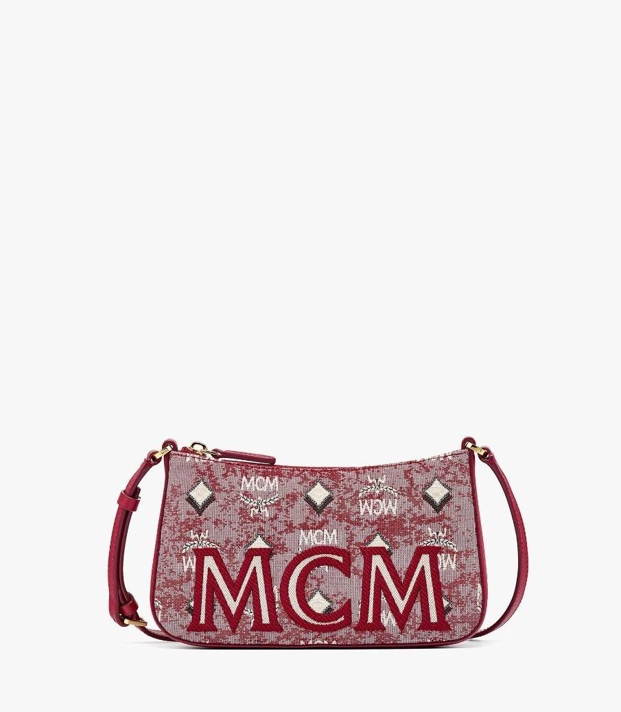 M.C.M MINI SHOULDER BAG IN VINTAGE JACQUARD MONOGRAM คอลเลคชั่นใหม่ล่าสุด โดดเด่นด้วยลายโมโนแกรม ถักทอบนผ้า woven jacquard กระเป๋าสะพายทรงพอชที่ไม่ธรรมดา มาพร้อมสายสะพายในตัว สามารถปรับใช้ได้ 2 แบบ สายยาวสะพายข้าง หรือจะนำสายเส้นกลางออกและปรับใช้สะพายไหล่