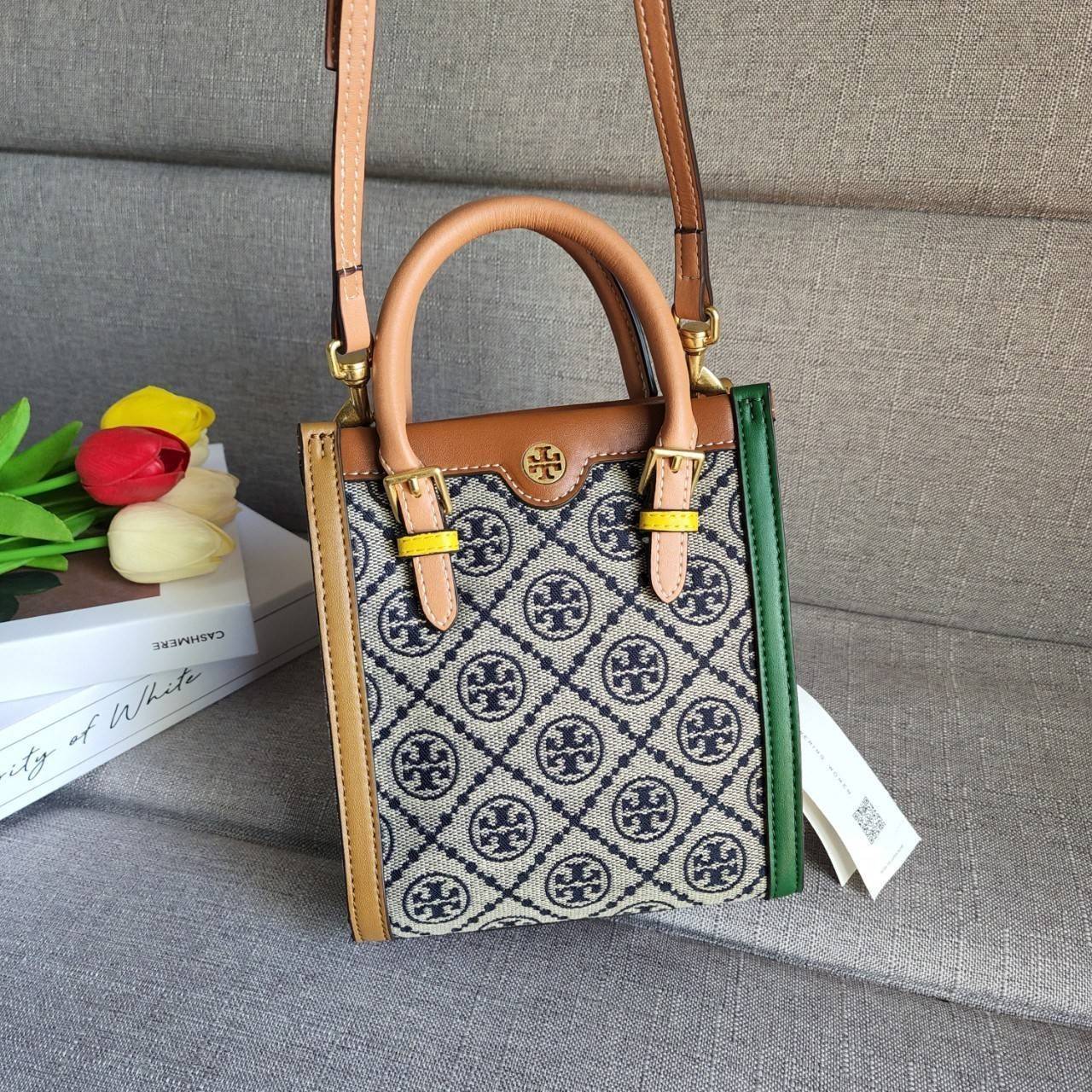 TORY BURCH T MONOGRAM COLORBlOCK JACQUARD MINI TOTE คอลเลคชั่นใหม่ล่าสุด ครอบครองก่อนใคร ไอเท็มยุคนี้รุ่นที่ควรมีติดตู้คะสาวๆ วัสดุ jacquard สลับหนังแท้ หูจับ มาพร้อมสายสะพายข้างหนังแท้ ปรับระดับได้ สายสามารถถอดออกได้ ภายในเป็นช่องโล่ง ใส่มือถือได้ กระเป๋