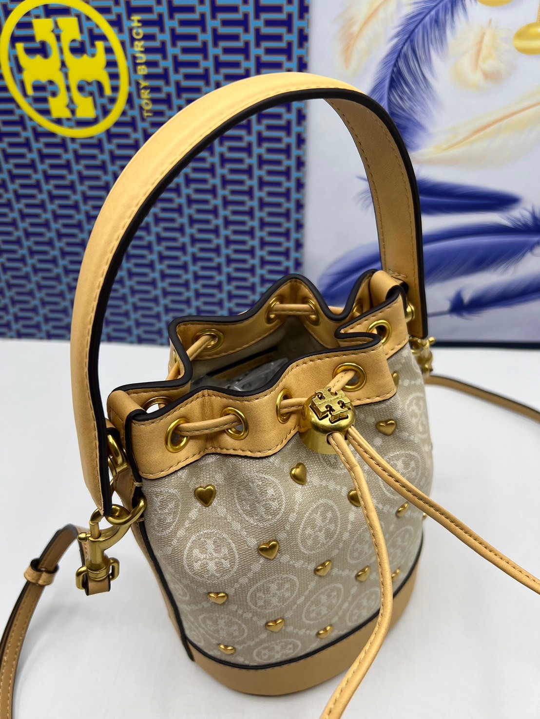 TORY BURCH T MONOGRAM EMBELLISHED MINI BUCKET BAG NEW IVORY MULTI กระเป๋าทรงบัคเก็ตแต่งหัวใจสีทองสวยหรู น่ารักรุ่นใหม่ล่าสุด เกรดท็อปออริ เทียบแท้ 1:1 เกรดดีสุด ใช้งานต่างประเทศได้
