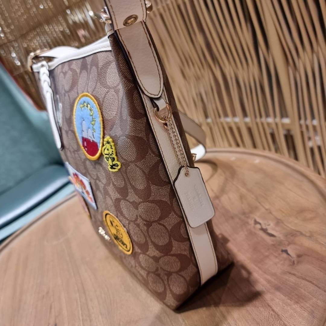 OUTLET 】COACH C4112 COACHxPEANUTS VAL DUFFLE IN SIGNATURE CANVAS WITH VARSITY PATCHES ใหม่ล่าสุด กระเป๋าทรงดัฟเฟิล ที่มาพร้อมเหล่าผองเพื่อนสนูปพี สวยมีเอกลักษณ์ ทรงกระเป๋าไม่ซ้ำใคร แถมยังใส่ของได้จุใจไปอีก วัสดุหนังแคนวาสคุณภาพดี ด้านหลังมีช่องซิป กระเป๋า