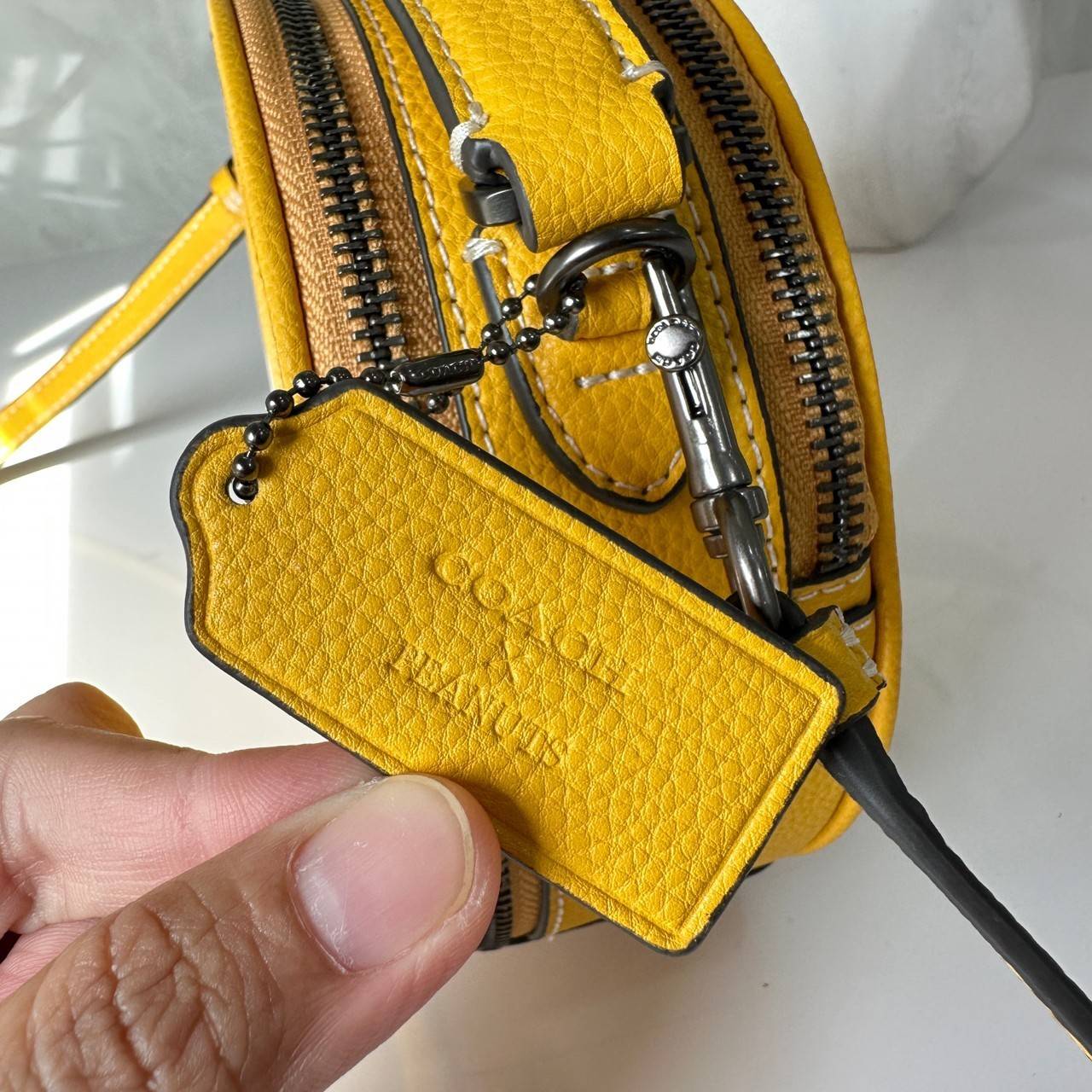 COACH X PEANUTS CANTEEN CROSSBODY WITH SNOOPY PRESENT MOTIF (CE845,CF290) กระเป๋าสะพายข้างทรงกลมไซส์มินิ มีหูจับ วัสหนังแท้ ด้านหน้าโดดเด่นด้วยรูปการ์ตูนSnoopy