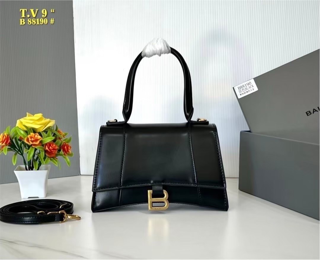 BALENCIAGA Hourglass top-handle tote bag กระเป๋าสะพายแบรนด์หรูซิกเนเจอร์ ที่มาพร้อมดีไซน์โดดเด่น มีความโฉบเฉี่ยว โค้งมนเหมือนพระจันทร์เสี้ยว เพิ่มความสวยสะดุดตาด้วยการตกแต่งอักษร B เมทัลลิก