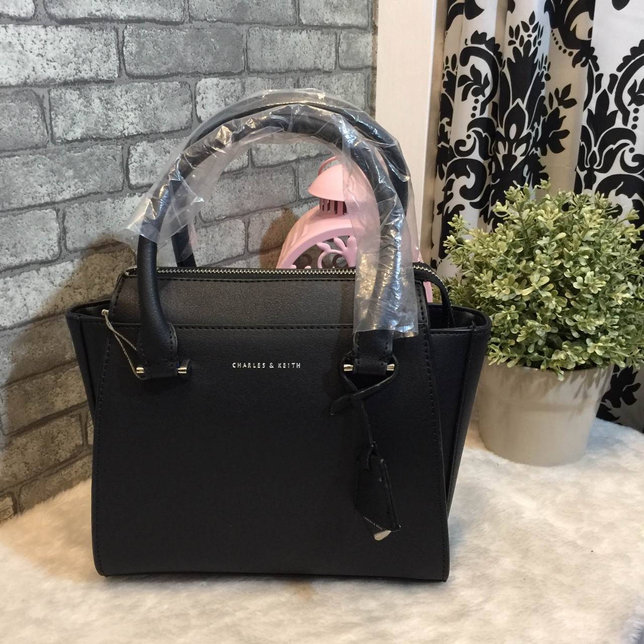 CHARLES & KEITH MINI CITY BAG กระเป๋าถือหรือสะพาย ขนาดกะทัดรัด กำลังดี หนังpu เรียบ อยู่ทรงแข็ง เปิด-ปิดด้วยซิป ด้านหน้าห้อยประดับอะไหล่ปั๊มโลโก้ ดูเรียบหรู ภายในมีช่องซิปเล็ก 1 ช่อง มาพร้อมสายสะพายยาวปรับได้ ฐานมีหมุดรองฐานกันรอยสี่มุม สะพายสบายๆไปเที่ยว