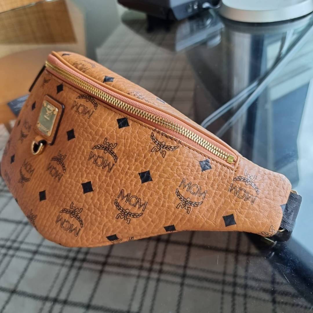 M.C.M FURSTEN BELT BAG IN VISETOS กระเป๋าคาดอกยอดฮิต หนุ่มๆสาวๆใช้ได้ไม่มีเบื่อ รุ่นขายดี ลายวิเซโต้เอกลักษณ์ ทั้งสปอร์ตและดูหรูในตัว ใช้งานง่าย ได้ทุกลุค วัสดุหนังแคนวาสคุณภาพดี มีช่องซิปหลัก และซิปด้านหลังกระเป๋า ภายในเป็นช่องโล่งบุผ้าซับอย่างดี รุ่น un