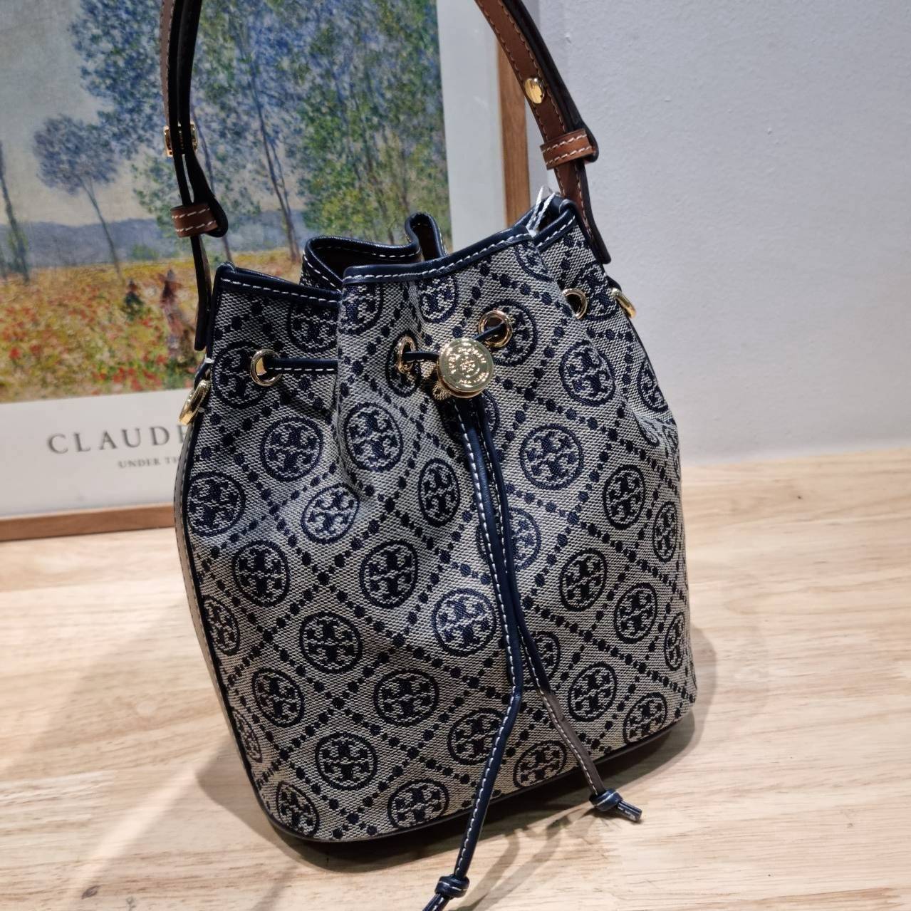 TOP ORI หนังแท้ | เกรดดีสุด TORY BURCH T MONOGRAM BUCKET BAG (ดีไซน์ใหม่) ใหม่ล่าสุดได้สวยก่อนใคร กับกระเป๋าบัคเก็ตยอดฮิต ที่มาในดีไซน์ใหม่ สายคล้องในตัวสามารถปรับได้ รูปทรงและลวดลายสวยชัดคลาสสิค