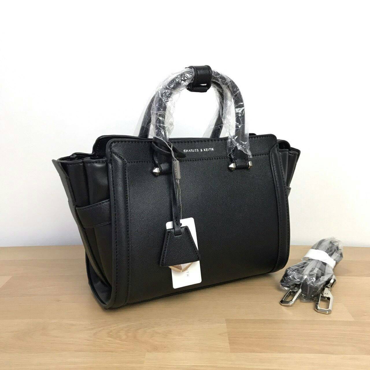 CHARLES & KEITH TRAPEZE BAG Best sellwr ! กระเป๋าถือหรือสะพายรุ่นยอดนิยมดีไซน์สวยหรูวัสดุหนัง คาเวียร์อยู่ทรง ด้านข้างเเต่งหนังช่องตัดดูมีดีเทล ด้านหน้าสกรีนโลโก้ ด้านหลังมีช่องซิป เปิดปิดด้วยซิปหัวซิป ปัํ๊มโลโก้ หูจับเเข็งแรง พับลงได้ พร้อมสายสะพายหนังปร