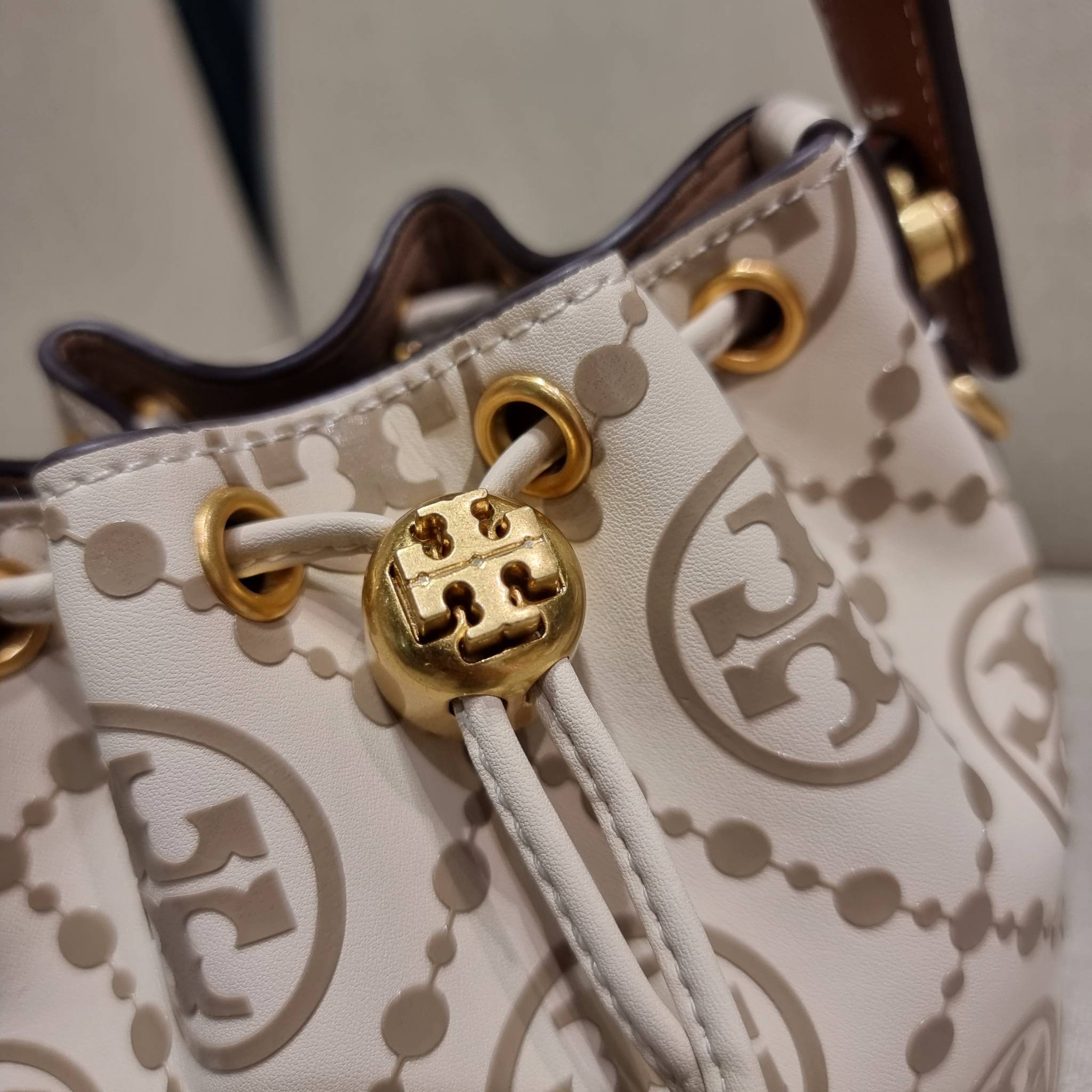 TORY BURCH T MONOGRAM EMBOSSED MINI BUCKET BAG คอลเลคชั่นใหม่ กับกระเป๋าบัคเก็ตทรงยอดนิยม ในไซส์มินิ ดีไซน์ใหม่ล่าสุด สวยลูกคุณหนู หรูหรา!! ด้วยดีเทลผิวลายนูนลวดลายเอกลักษณ์ วัสดุหนังแท้ ปากกระเป๋ารูดเปิด-ปิดได้ มีหูจับในตัว สะดวกใช้ไปอีก และมีสายสะพายข้า