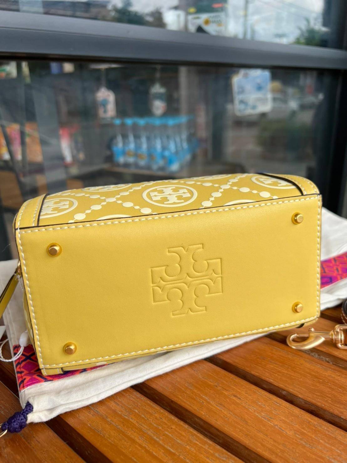 Tory Burch T-Monogram Mini Embossed Wine Bucket Bag / Tory Burch Mini Bucket กระเป๋าถือหรือสะพายไหล่ ทรงหมอนขนาดเล็ก ประดับด้วยลวดลายอันเป็นสัญลักษณ์ของแบรนด์ ถูกประดิษขึ้นด้วยความพิถีพิถันวัสดุหนังอย่างดี ด้านในบุด้วยหนังไมโครซูแอคเนื้อนุ่มทำความสะอาดง่า