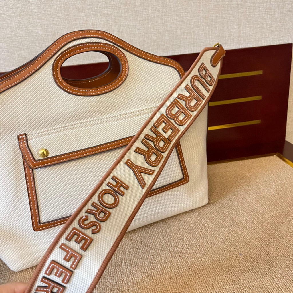 Burberry Pocket Compact Tote Bag กระเป๋าสะพาย burberry ทรงtote ผ้าแคนวาสตัดขอบทูโทน แต่งกระเป๋าด้านหน้า ช่องกว้างใส่ของได้เยอะเลยค่ะ มาพร้อมสายสะพายยาว งานสวยเป๊ะ