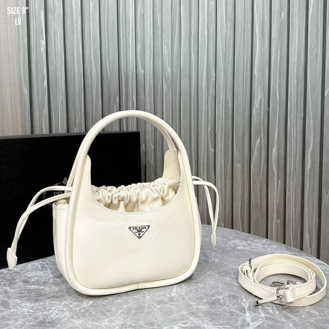 PRADA leather handbag กระเป๋าถือดีไซน์สวย ใช้งานง่าย มีกระเป๋าผ้าเชือกผูกเพิ่มกิมมิกได้อย่างลงตัวน่ารัก มาพร้อมสายสะพายยาวถอดได้ ปรับใช้ได้กับทุกลุคและแมทช์กับทุกสไตล์ แนะนำเลยจ้า