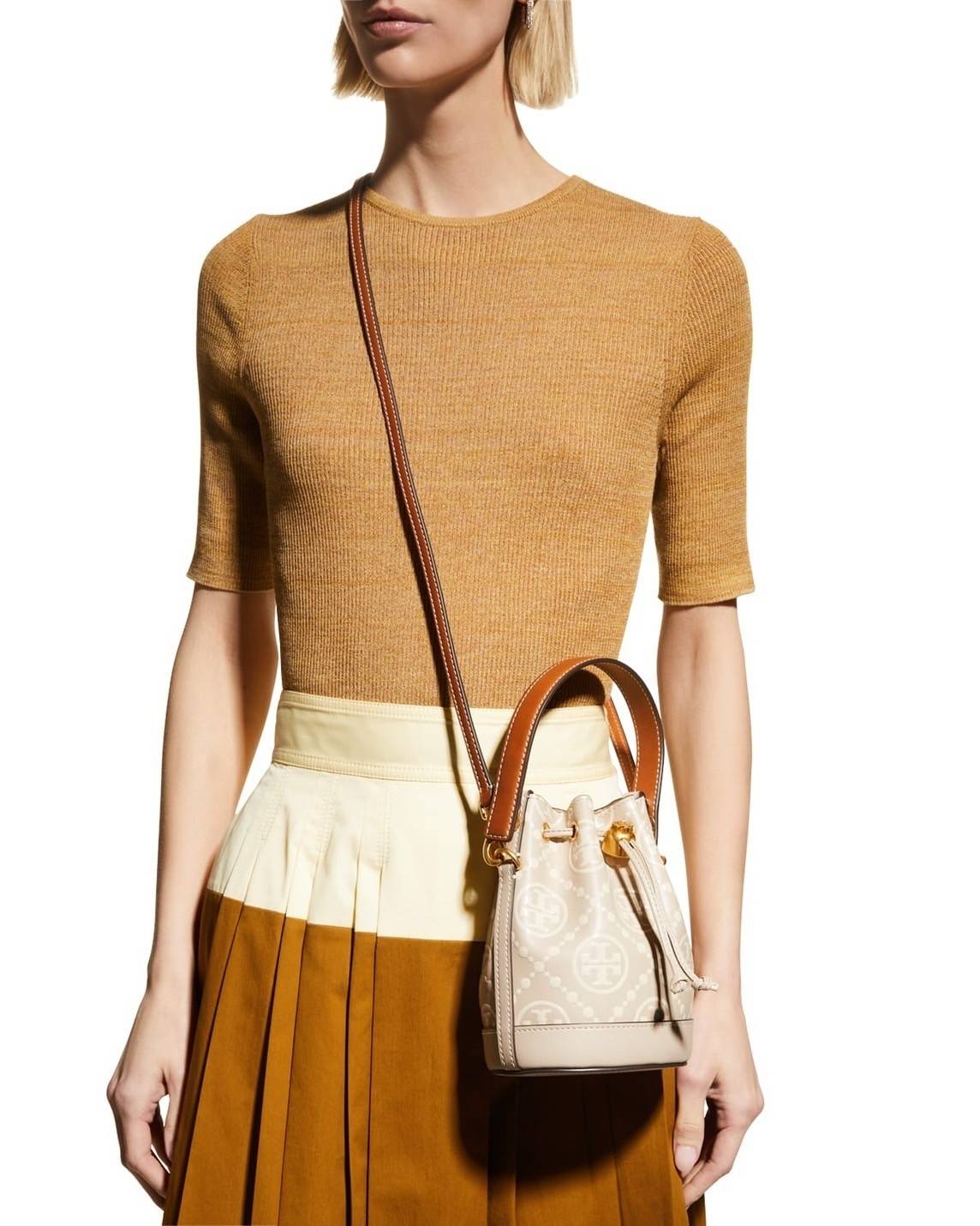 Tory Burch T Monogram Embossed Mini Bucket Bag กระเป๋าทรงถังขนาดเล็ก ประดับด้วยลวดลายอันเป็นสัญลักษณ์ของแบรนด์ ถูกประดิษขึ้นด้วยความพิถีพิถันวัสดุหนังอย่างดี ด้านในบุด้วยหนังไมโครซูแอคเนื้อนุ่มทำความสะอาดง่าย อะไหล่ทองหรูหรา มาพร้อมสายยาว ปรับสายได้ ถอดสา