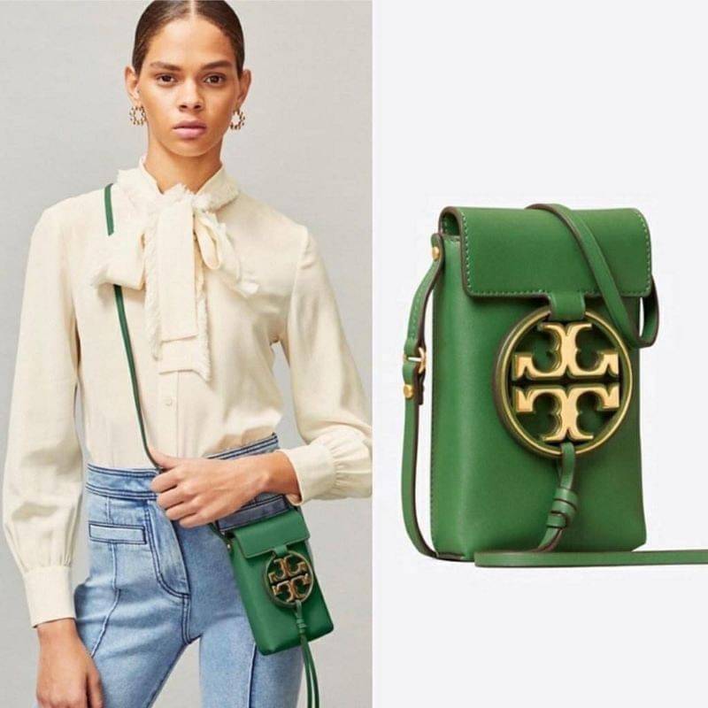TORY BURCH MILLER METAL PHONE CROSSBODY อีกหนึ่งกระเป๋าใส่มือถือรุ่นฮิตที่เชื่อว่าหลาย ๆ คนต้องเคยเห็นผ่าน ๆ ตามาอย่างแน่นอน กับแบรนด์ Tory Burch ดีไซน์กระเป๋าทรงฝาพับแม่เหล็กใช้งานง่าย มาพร้อมดีเทล Logo แบรนด์โดดเด่นสีทองตัดกับหนังแกะสีดำ ดูหรูดูแพง! แต่