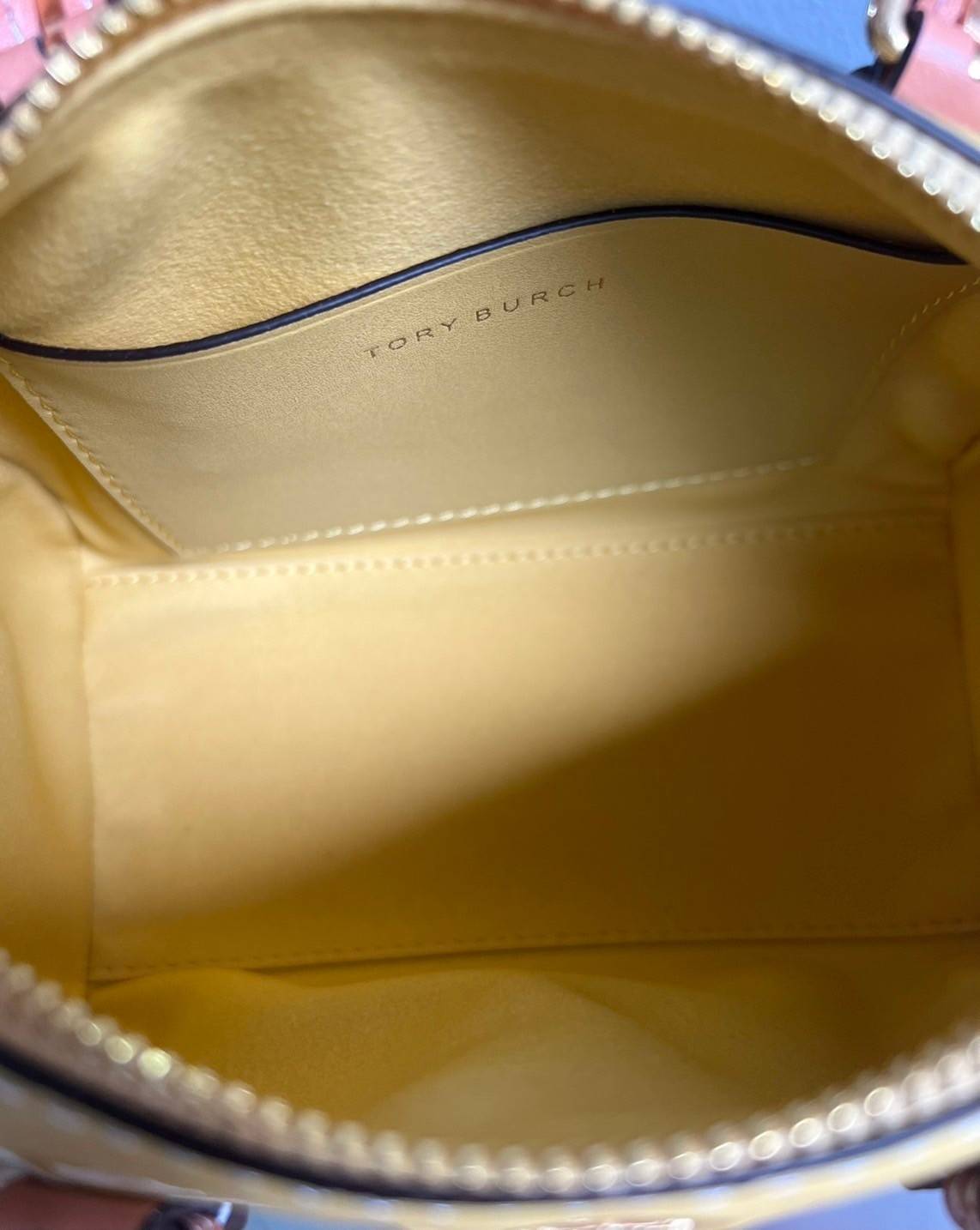 Tory Burch T-Monogram Mini Embossed Wine Bucket Bag / Tory Burch Mini Bucket กระเป๋าถือหรือสะพายไหล่ ทรงหมอนขนาดเล็ก ประดับด้วยลวดลายอันเป็นสัญลักษณ์ของแบรนด์ ถูกประดิษขึ้นด้วยความพิถีพิถันวัสดุหนังอย่างดี ด้านในบุด้วยหนังไมโครซูแอคเนื้อนุ่มทำความสะอาดง่า