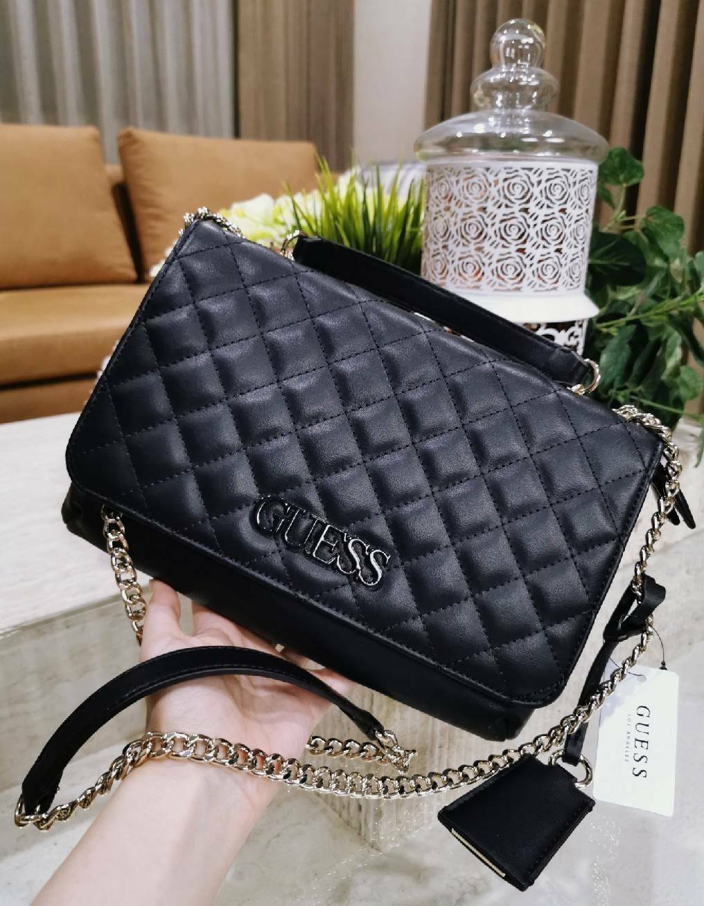 GUESS CROSSBODY BAG กระเป๋าสะพายรุ่นใหม่ล่าสุดทรงเหลี่ยมหนังนิ่มสวยเดินเส้นลายตารางอยู่ทรงด้านหน้าประดับโลโก้ GUESS สวยดูมีเปิดปิดด้วยฝาปิด ภายในมีช่องแบ่งสองช่องเป็นสัดส่วนใส่กระเป๋าสตางค์ใบยาว มือถือ ของจุกจิกได้เยอะ พร้อมสายสะพายโซ่ต่อหนังจะเลื่อนใช้สา