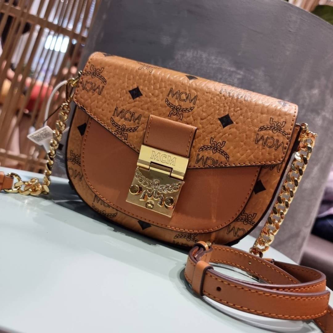 M.C.M MINI PATRICIA CROSSBODY IN VISETOS กระเป๋าสะพายไซส์มินิ แรงดีไม่มีตกน้า คอลเลคชั่นนี้ดีไซน์แปลกใหม่ ทรงโค้งมน สวยหรู ด้านข้างตกแต่งหมุดทองรอบใบ วัสดุตัวกระเป๋าเป็นหนังแคนวาสคุณภาพดี ภายในเป็นหนังกลับสีส้มโดดเด่นเป็นเอกลักษณ์ มีช่องใส่บัตรแยกให้ เปิด