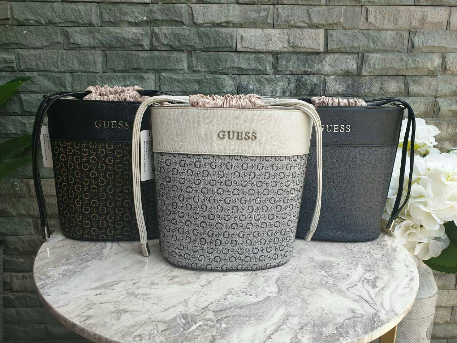 3สี Guess Bucket Bag กระเป๋ารุ่นใหม่ล่าสุด อวดไอเทมแสนเก๋กับกระเป๋าทรงถังสุดน่ารัก พิมพ์ลายรอบใบ วัสดุ Saffiano PU คุณภาพดี นิ่ม น้ำหนักเบา ด้านหน้าประดับด้วยโลโก้แบรนด์สวยโดดเด่น เปิดปิดด้วยเชือกหนังใช้หูรูดปลายเชือกประดับอะไหล่เงินสะดวกใช้ ด้านในโล่งกว้