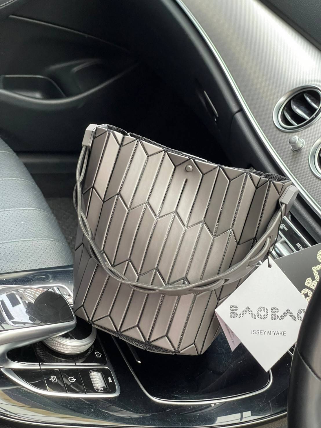 Small : BAO BAO ISSEY MIYAKE SMALL BUCKET เป็นกระเป๋าบัคเก็ตขนาดเล็กสามารถใช้ใส่กระเป๋าสตางค์และโทรศัพท์มือถือได้ ซีรีย์ใหม่นี้มีจุดเด่นที่แผ่นรูปทรงสี่เหลี่ยมด้านขนานในแนวตั้ง เกิดเป็นรูปทรงสามมิติซึ่งแตกต่างไปจากรูปทรงที่เกิดขึ้นจากแผ่นสามเหลี่ยม หูหิ้ว