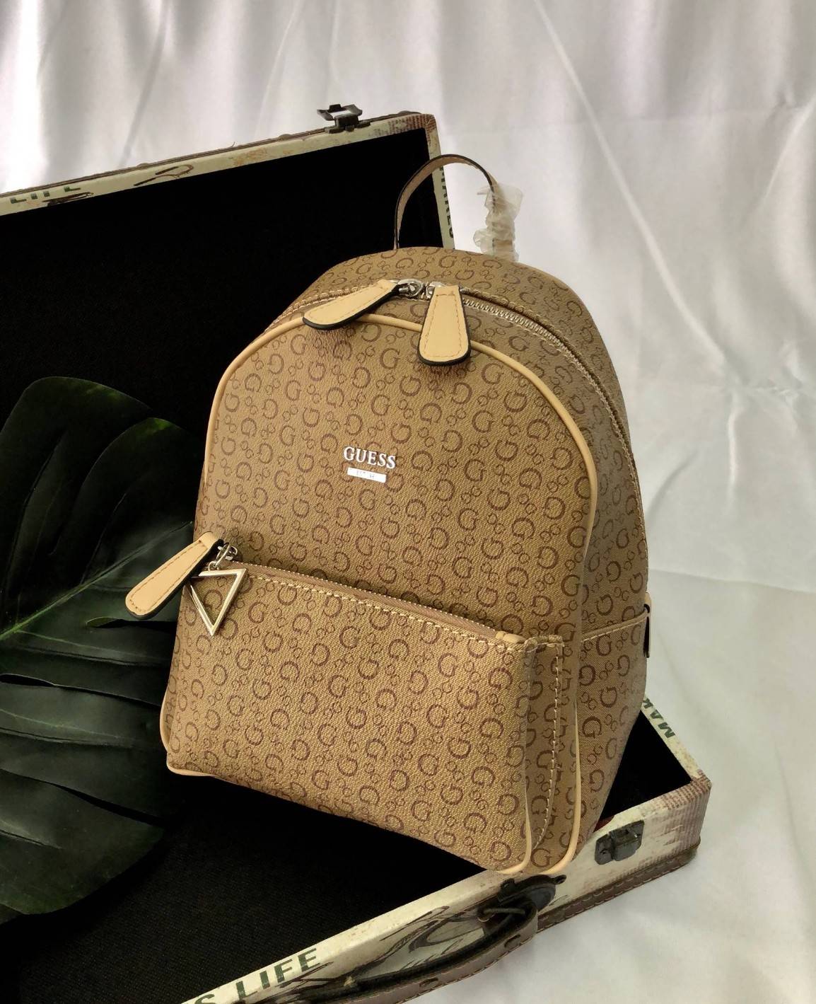 GUESS PANDORE BACKPACK กระเป๋าสะพายหลัง วัสดุหนังนิ่มมือ น้ำหนักเบา ด้านหน้ามีโลโก้แบรนด์ พร้อมช่องซิปหนึ่งช่อง ที่จับซิปมีอะไหล่สัญลักษณ์แบรนด์ ช่องซิปหลักเปิดปิดด้วยซิปคู่ ภายในโล่ง กว้าง ใส่ของได้จุ มีช่องซิปและช่องเล็กใส่ของจุกจิก สายสะพายด้านหลังเลื่