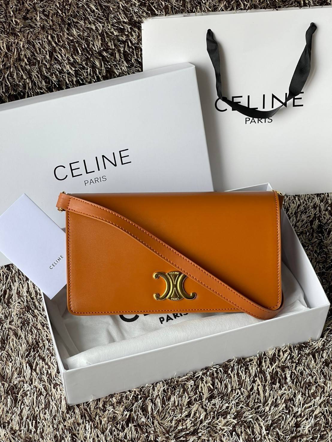 CELINE TRAPEZE TRIOMPHE BAG ดีไซน์เรียบหรู Timeless โดดเด่นมีเอกลักษณ์ ใช้ได้หลายโอกาส แมทช์กับการแต่งตัวง่าย จึงครองใจสาว ๆ ได้ไม่ยาก โดยเป็นกระเป๋าสะพายไหล่ที่อัดแน่นด้วยกลิ่นอายความคลาสสิกและหรูหราตามแบบฉบับของ Celine ด้านหน้าตกแต่งด้วยโลโก้สีทองโดดเด่