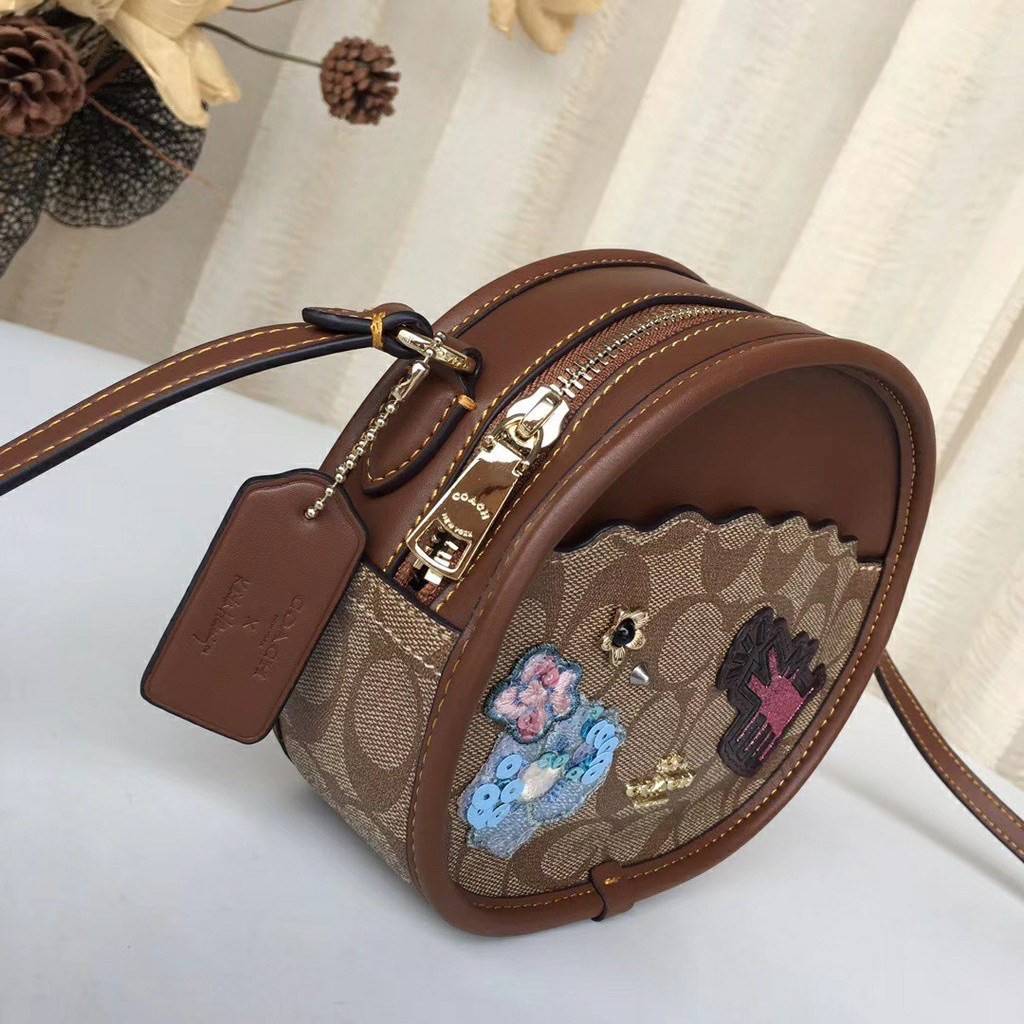 COACH KEITH HARING CANTEEN CROSSBODY IN SIGNATURE CANVAS WITH PATCHES F48730 กระเป๋าทรงกลมสุดเก๋ ไม่เหมือนใคร ตกแต่งลายให้มรความน่ารัก โดดเด่นขึ้นมา สะพายไปไหนก็สวยไม่เหมือนใคร ภายในกว้าง ใส่ของได้เยอะ กระเป๋าเปิดปิดด้วยซิป ใครย้งไม่มี รีบจับ รีบจองกันเลย