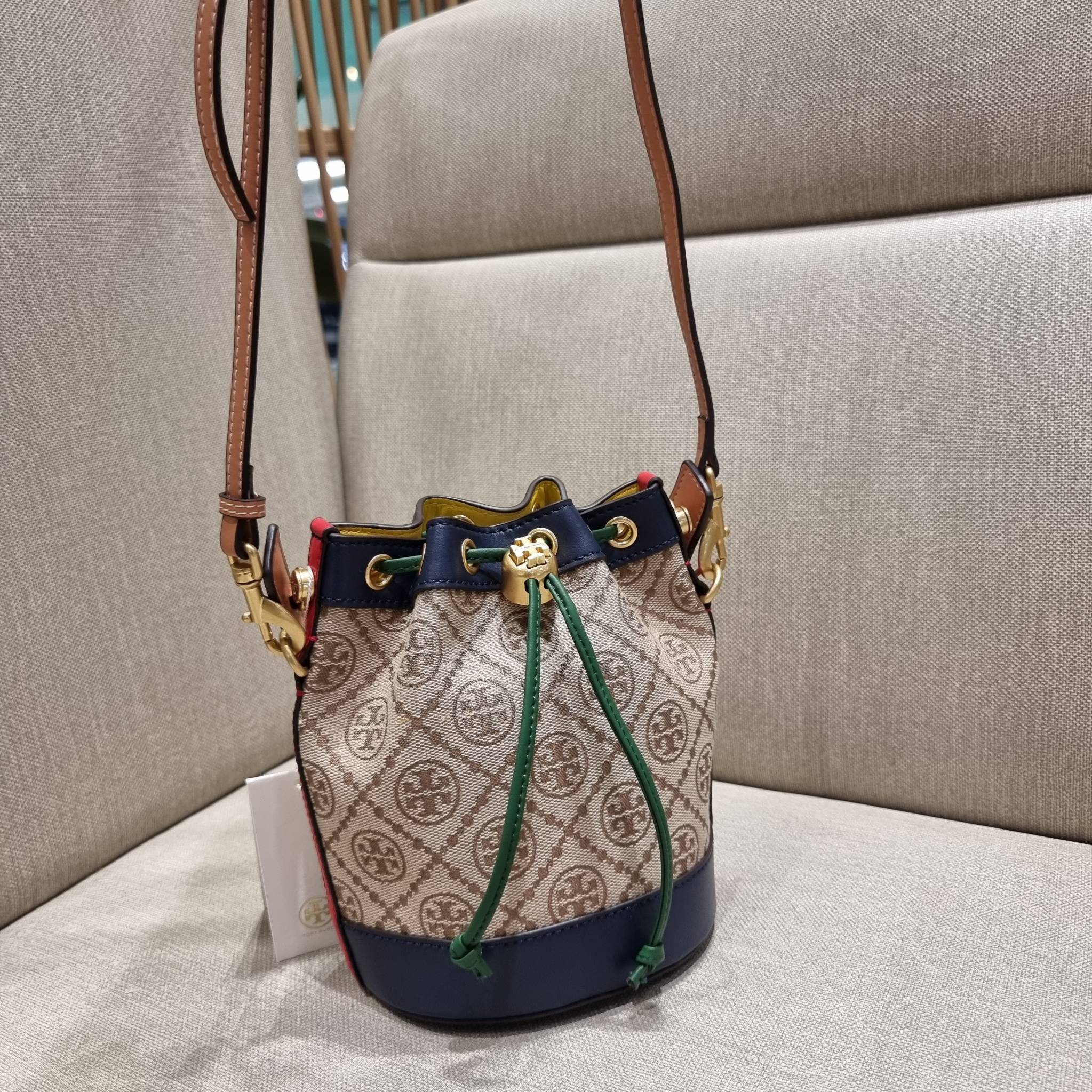 MINI : TORY BURCH T MONOGRAM COLOR-BLOCK JACQUARD MINI BUCKET BAG ใหม่ล่าสุด กับกระเป๋าบัคเก็ตทรงสวย ไซส์มินิ ในราคาน่ารัก โดดเด่นด้วยลวดลายเอกลักษณ์ ผสานลายคัลเลอร์บล็อค โทนสีตัดกันอย่างลงตัว ถักทอบนวัสดุ woven jacquard ลายคมชัด สลับส่วนของหนังแท้ ภายในเ